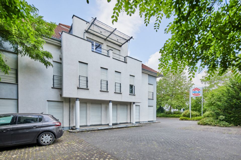 linke Gebäudeseite mit Parkplatz